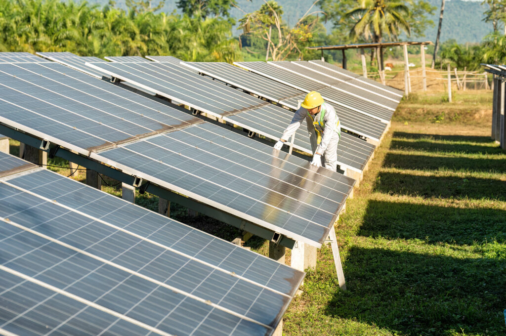 Ein Arbeiter arbeitet auf einem Feld an Sonnenkollektoren.